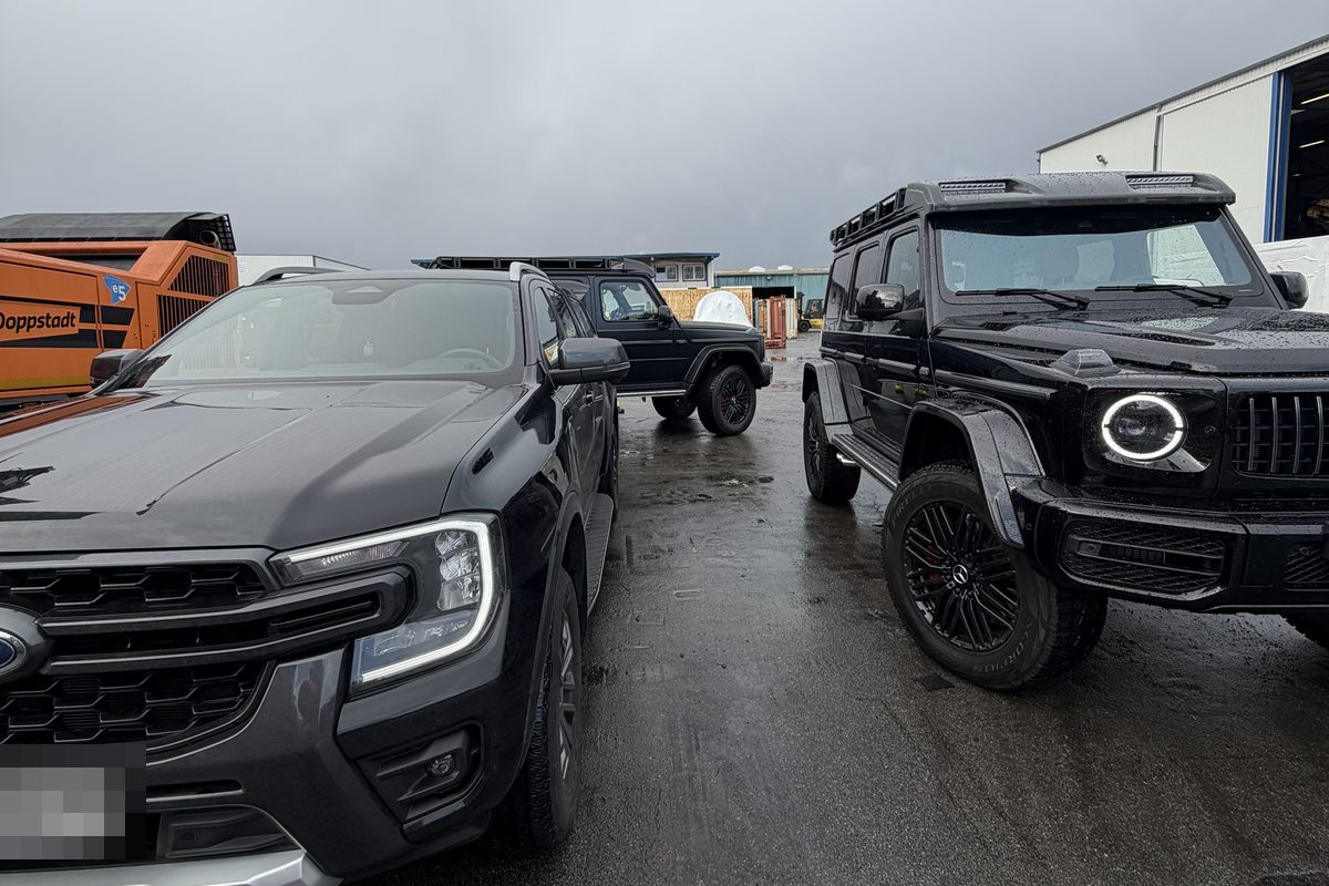 Geländewagen und Pickup auf einem Speditionshof
