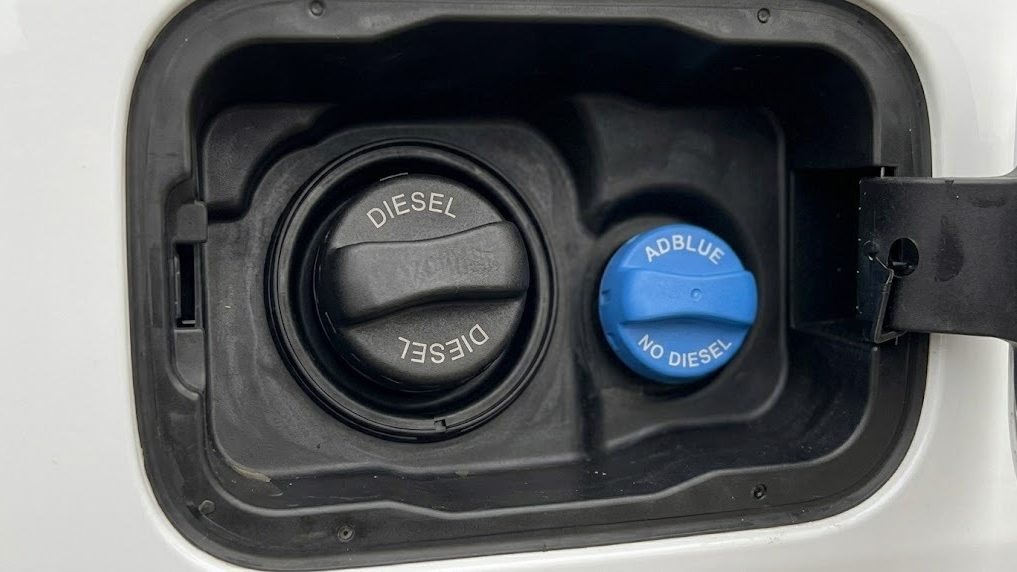 Geöffnete Tankklappe mit schwarzem Dieselverschluss und blauem AdBlue-Verschluss direkt daneben