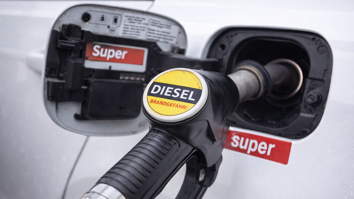 Diesel-Zapfpistole am Tankstutzen eines Fahrzeugs, dessen Tankklappe Super ausweist